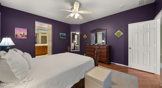 bedroom with dark hardwood / wood-style floors, ceiling fan, and ensuite bathroom