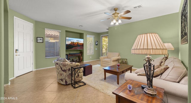 living room featuring ceiling fan, light tile patterned flooring, and a fireplace