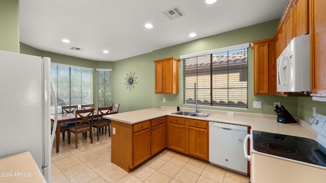 kitchen with kitchen peninsula, white appliances, sink, and light tile patterned flooring