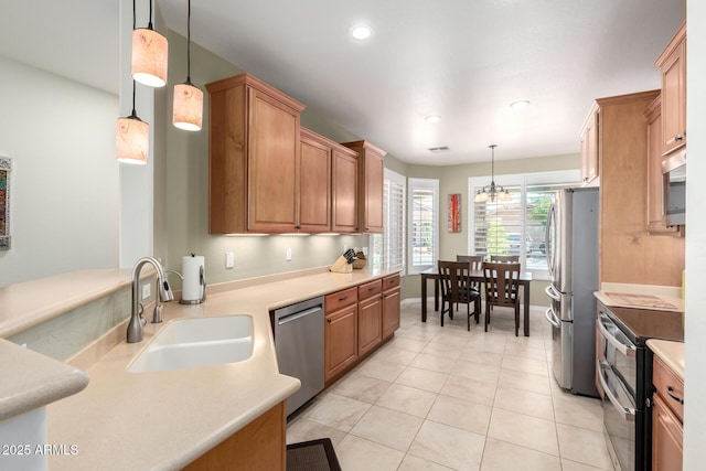 kitchen with recessed lighting, stainless steel appliances, light countertops, a sink, and pendant lighting