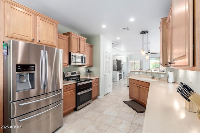 kitchen featuring light tile patterned floors, appliances with stainless steel finishes, light countertops, a sink, and visible vents