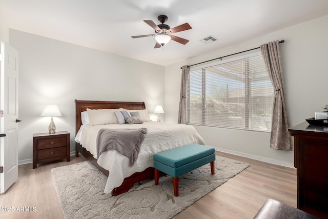 bedroom featuring visible vents, a ceiling fan, light wood-style flooring, and baseboards