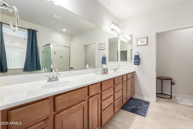 bathroom with double vanity, a sink, a shower stall, and tile patterned floors