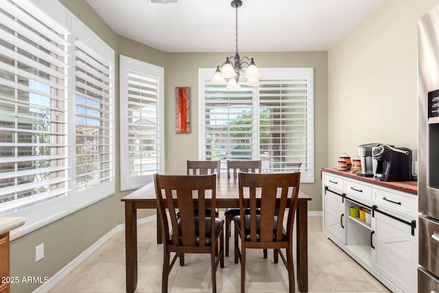 dining room featuring baseboards, an inviting chandelier, and light tile patterned flooring