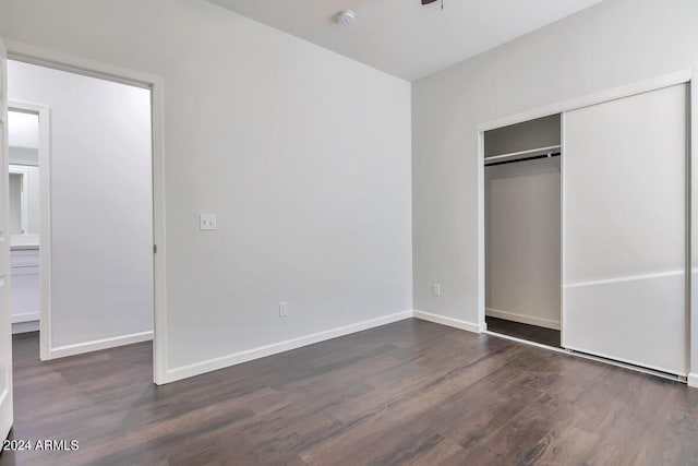 unfurnished bedroom featuring dark hardwood / wood-style floors and a closet