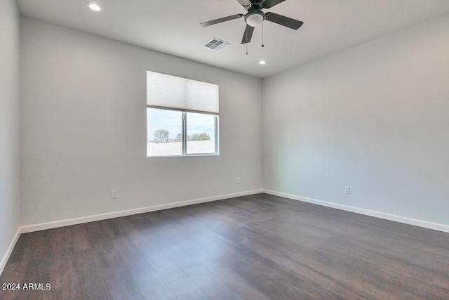 spare room featuring dark wood-type flooring and ceiling fan