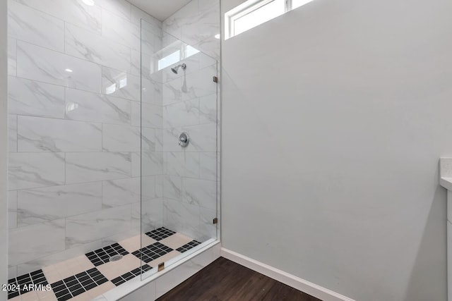 bathroom with hardwood / wood-style flooring and a tile shower