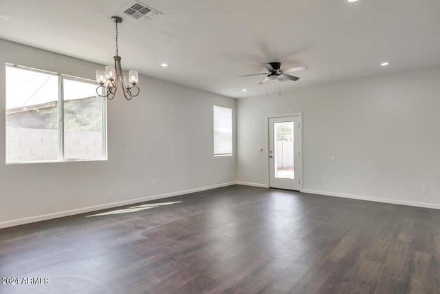 empty room featuring dark hardwood / wood-style flooring and ceiling fan with notable chandelier