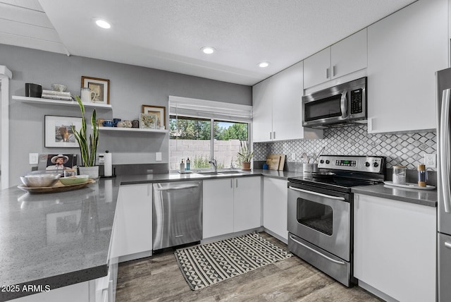4502 W Continental Dr, Glendale, AZ 85308 - kitchen with appliances with stainless steel finishes, a sink, white cabinetry, decorative backsplash, and recessed lighting