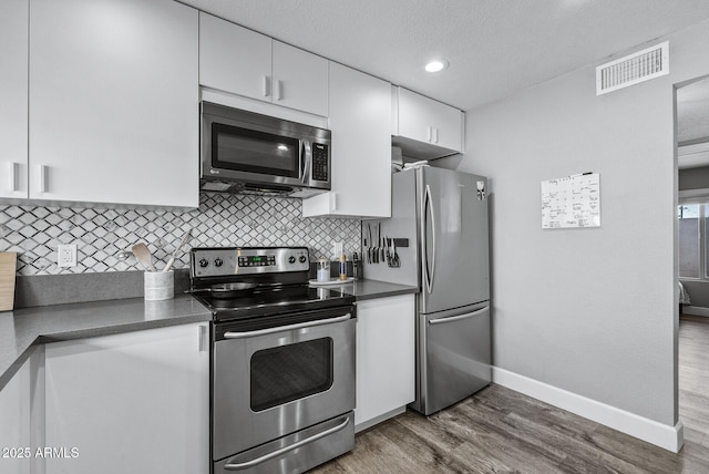 4502 W Continental Dr, Glendale, AZ 85308 - kitchen featuring appliances with stainless steel finishes, dark countertops, baseboards, white cabinets, and recessed lighting