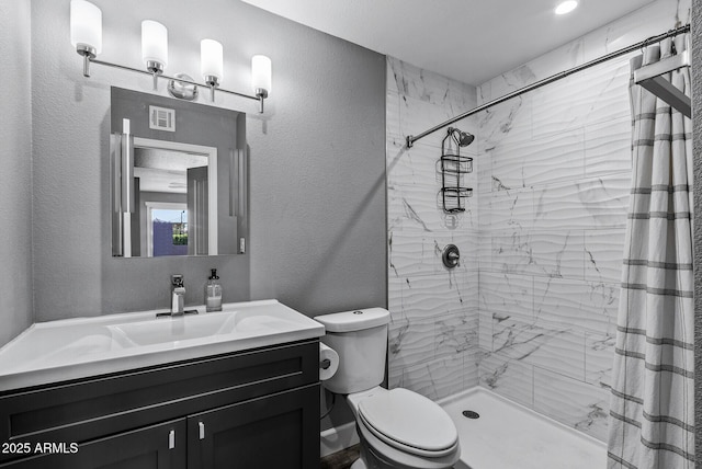 4502 W Continental Dr, Glendale, AZ 85308 - bathroom with toilet, vanity, a tile shower, and a textured wall