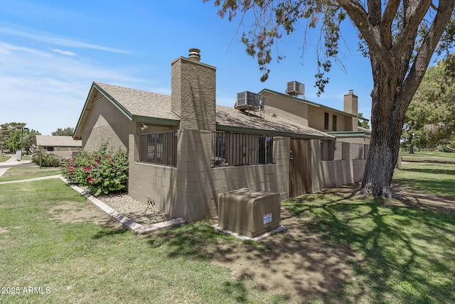 4502 W Continental Dr, Glendale, AZ 85308 - rear view of property with a chimney, central AC unit, and a shingled roof