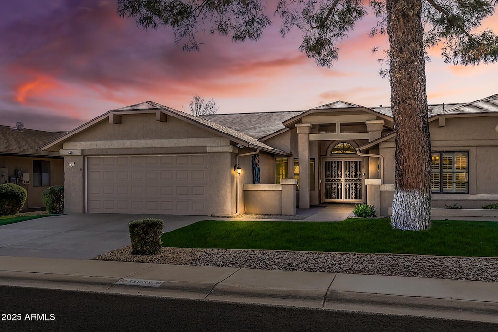 view of front facade with a lawn and a garage