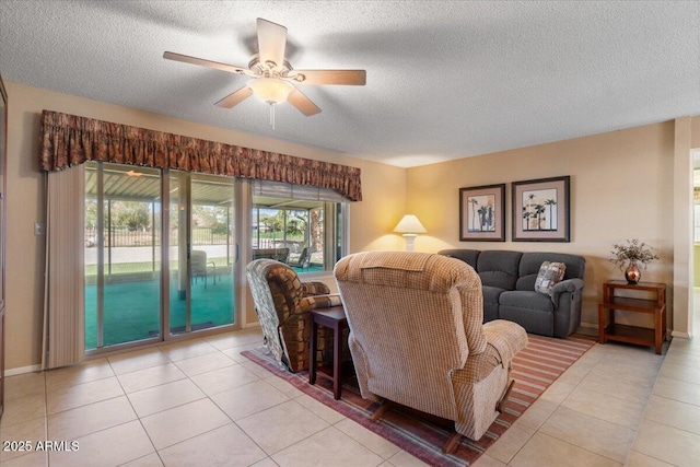 tiled living area with baseboards, a ceiling fan, and a textured ceiling