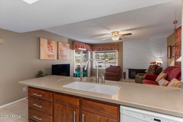 kitchen with light tile patterned floors, a textured ceiling, a sink, white dishwasher, and open floor plan