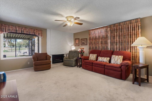 living area featuring a fireplace, a textured ceiling, a ceiling fan, and carpet floors