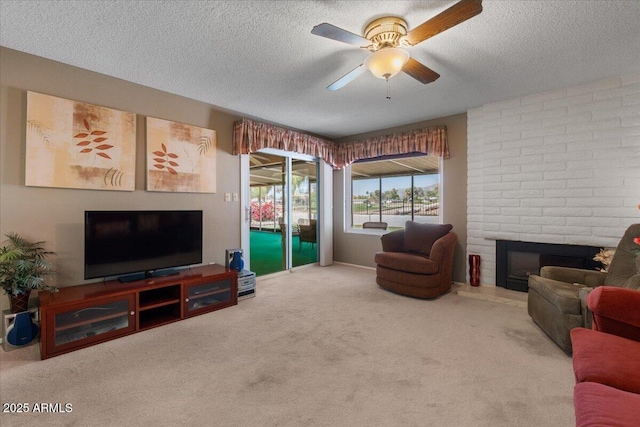 living room featuring a textured ceiling, carpet flooring, a ceiling fan, and a brick fireplace