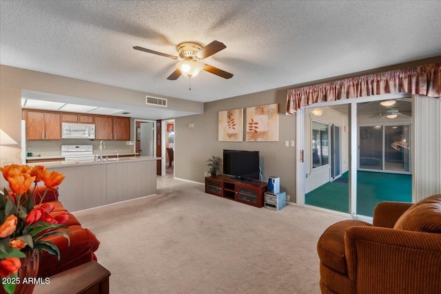 living room with visible vents, light colored carpet, a textured ceiling, and ceiling fan