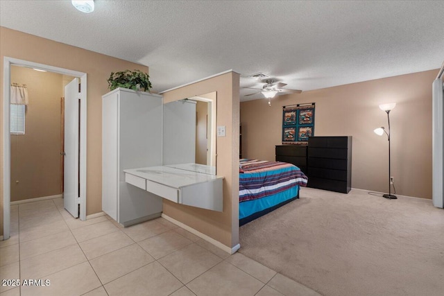 bedroom featuring light colored carpet, a textured ceiling, a ceiling fan, and light tile patterned flooring
