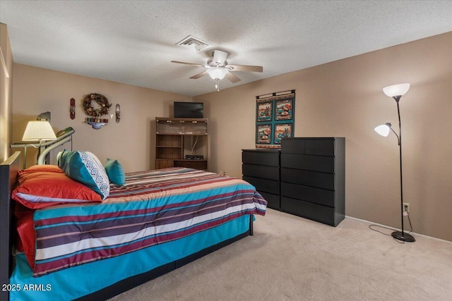 carpeted bedroom with visible vents, a textured ceiling, and ceiling fan