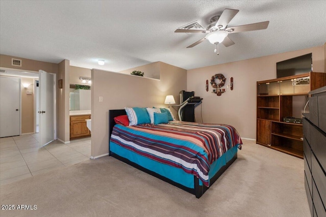 bedroom with light carpet, light tile patterned floors, visible vents, and a textured ceiling