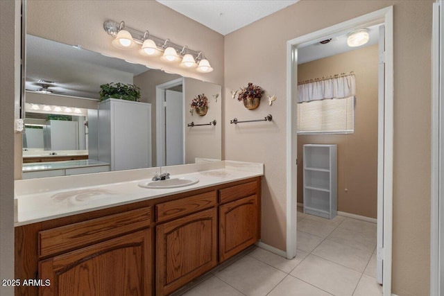 bathroom featuring tile patterned flooring, vanity, and baseboards