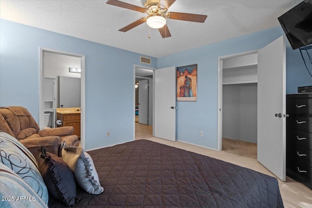 bedroom with visible vents, a spacious closet, light carpet, and a textured ceiling