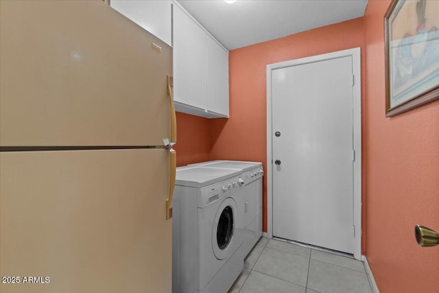washroom with light tile patterned floors, washer / dryer, and cabinet space