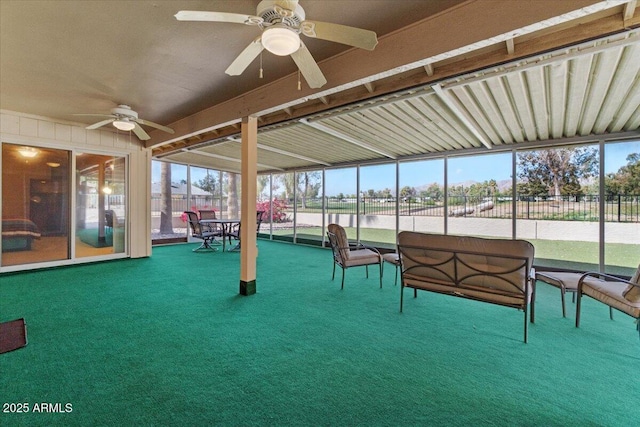 unfurnished sunroom with ceiling fan and an outdoor hangout area
