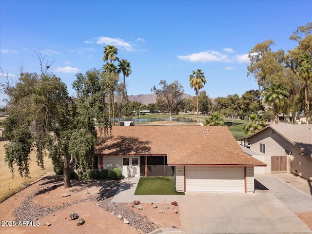 single story home with fence, a gate, an attached garage, a mountain view, and concrete driveway