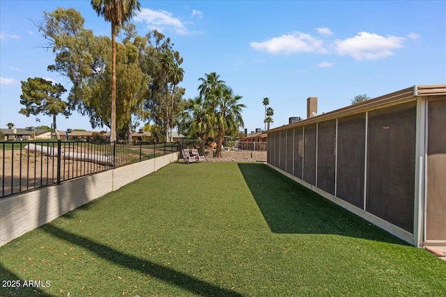 view of yard with a fenced backyard and a sunroom