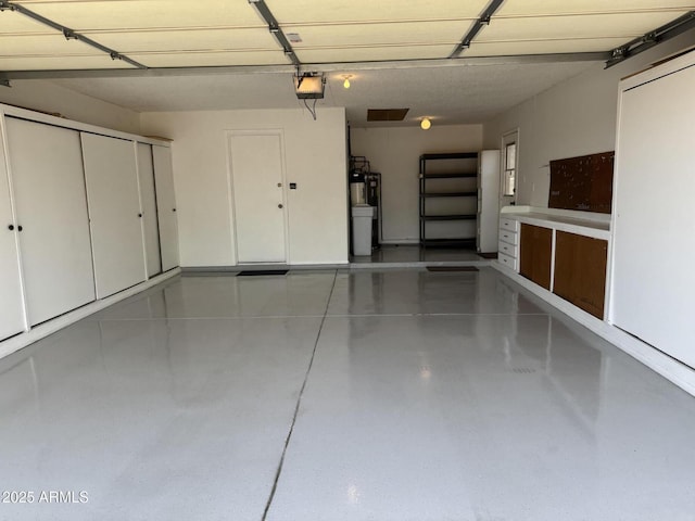 garage with water heater and a garage door opener