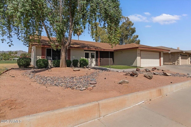 single story home featuring concrete driveway and an attached garage