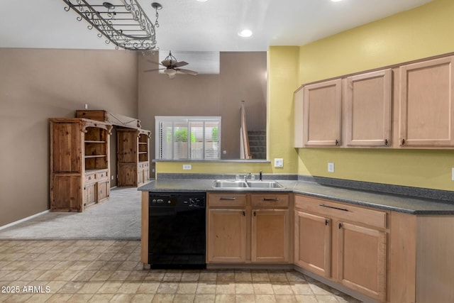 kitchen with a peninsula, dark countertops, ceiling fan, black dishwasher, and a sink