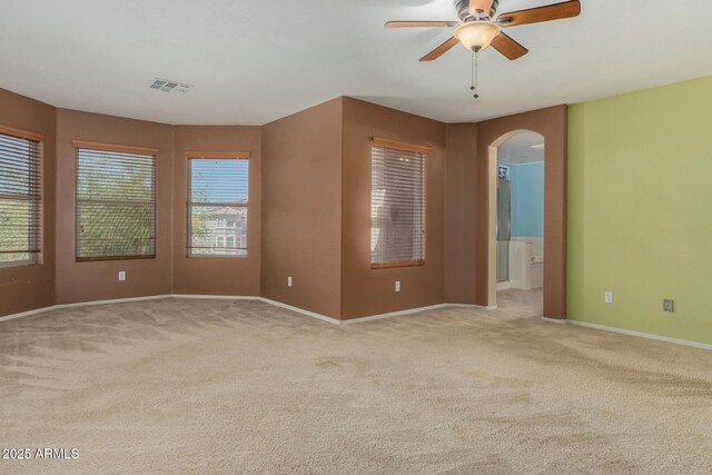 16527 N 71st Dr, Peoria, AZ 85382 - spare room featuring arched walkways, ceiling fan, visible vents, and light carpet