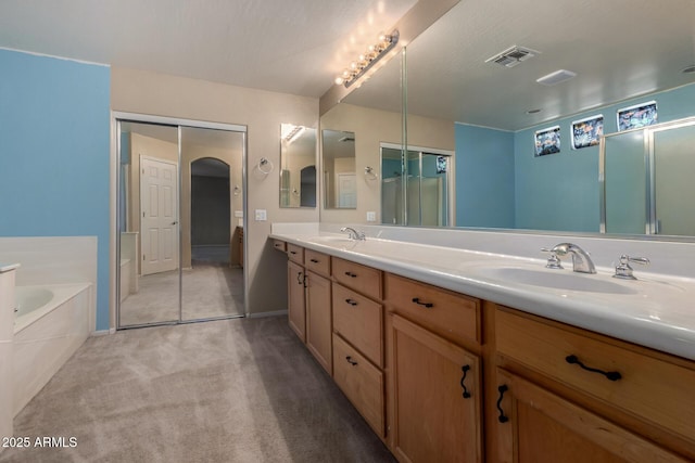 full bath with double vanity, visible vents, a sink, and a garden tub