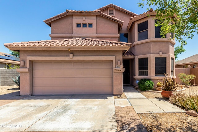 view of front of house featuring concrete driveway, a tile roof, and stucco siding