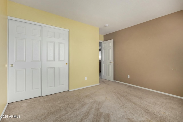 unfurnished bedroom with a closet, baseboards, and carpet flooring