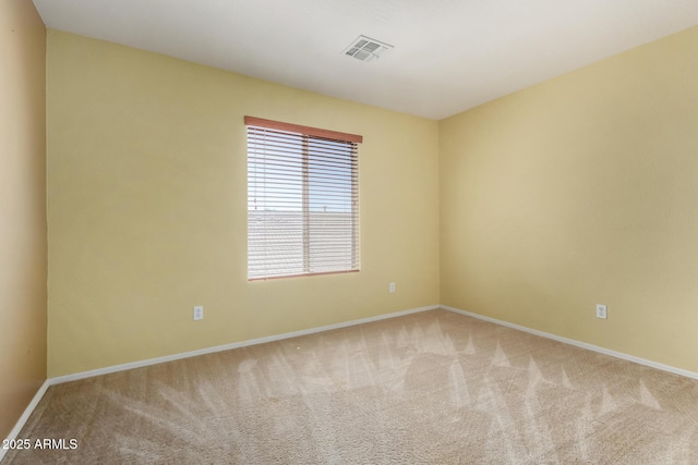 carpeted empty room featuring baseboards and visible vents