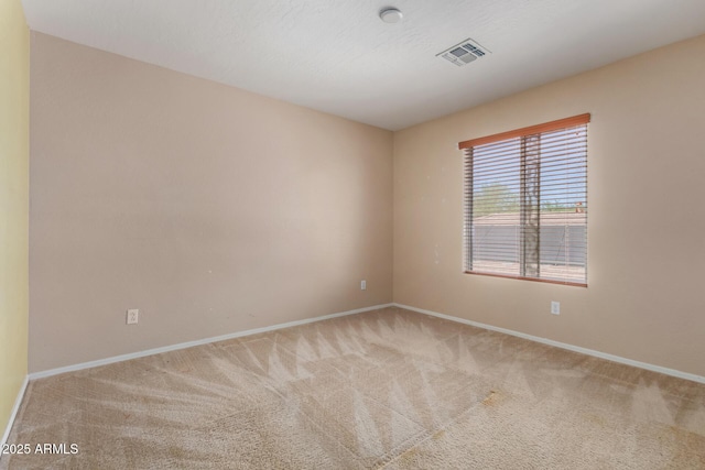 carpeted spare room with baseboards and visible vents