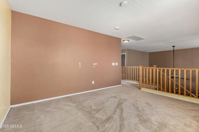 empty room with carpet floors, baseboards, and visible vents