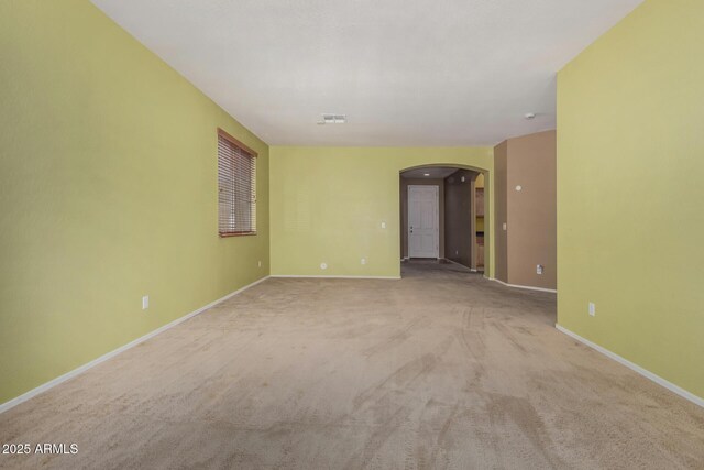 16527 N 71st Dr, Peoria, AZ 85382 - empty room featuring carpet floors, arched walkways, baseboards, and visible vents