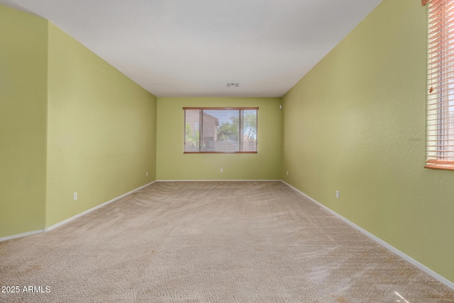 carpeted spare room with baseboards and visible vents