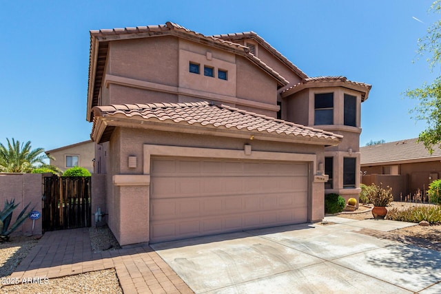 view of front of home with fence, a garage, stucco siding, a tiled roof, and driveway