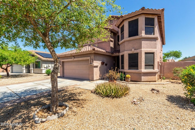 mediterranean / spanish home featuring a tiled roof, fence, concrete driveway, an attached garage, and stucco siding