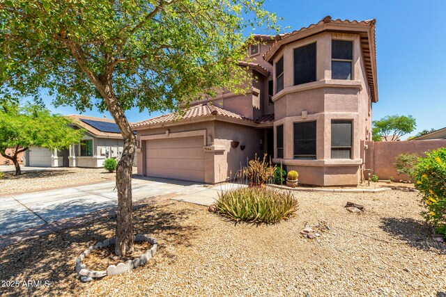 16527 N 71st Dr, Peoria, AZ 85382 - mediterranean / spanish home featuring a tiled roof, fence, concrete driveway, an attached garage, and stucco siding