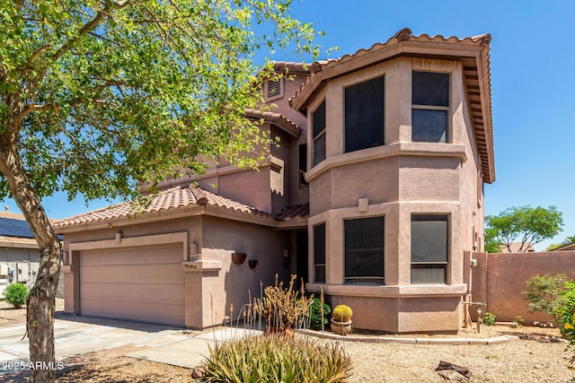 view of front of home featuring fence, an attached garage, stucco siding, a tiled roof, and driveway