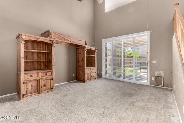 16527 N 71st Dr, Peoria, AZ 85382 - unfurnished living room with a ceiling fan, baseboards, light colored carpet, and a towering ceiling