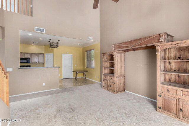 16527 N 71st Dr, Peoria, AZ 85382 - unfurnished living room with baseboards, a high ceiling, visible vents, and light colored carpet