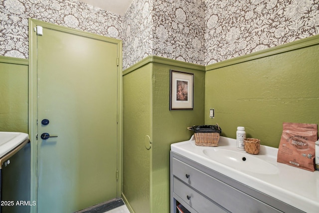 bathroom featuring vanity and wallpapered walls